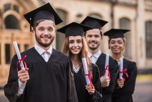 Young people dressed in graduation caps and gowns.
