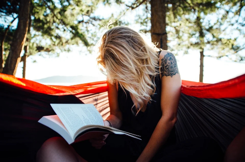 Women reading a book outdoors.