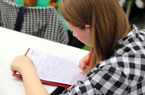 A student taking notes in a notebook.